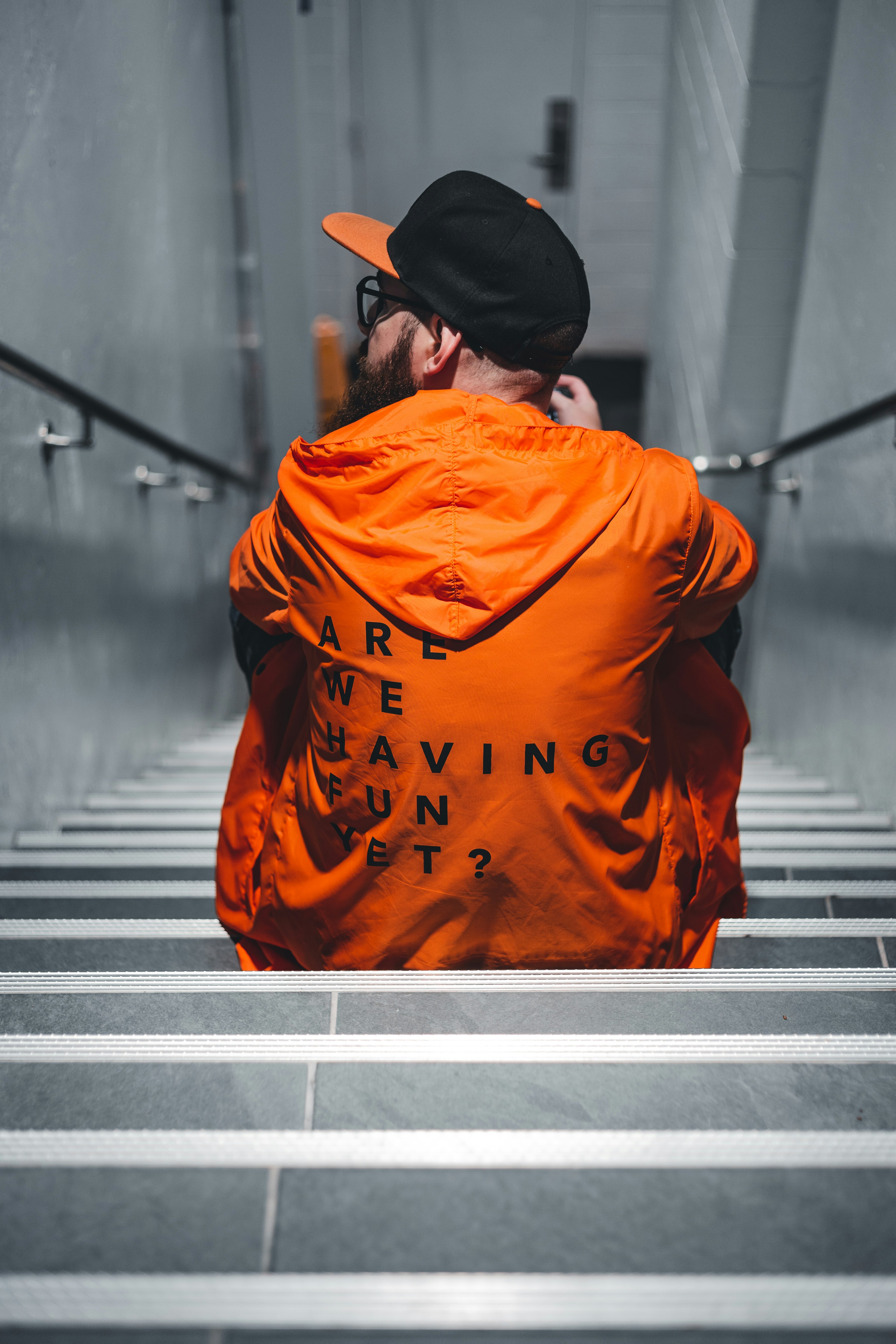 man in orange hoodie walking on stairs